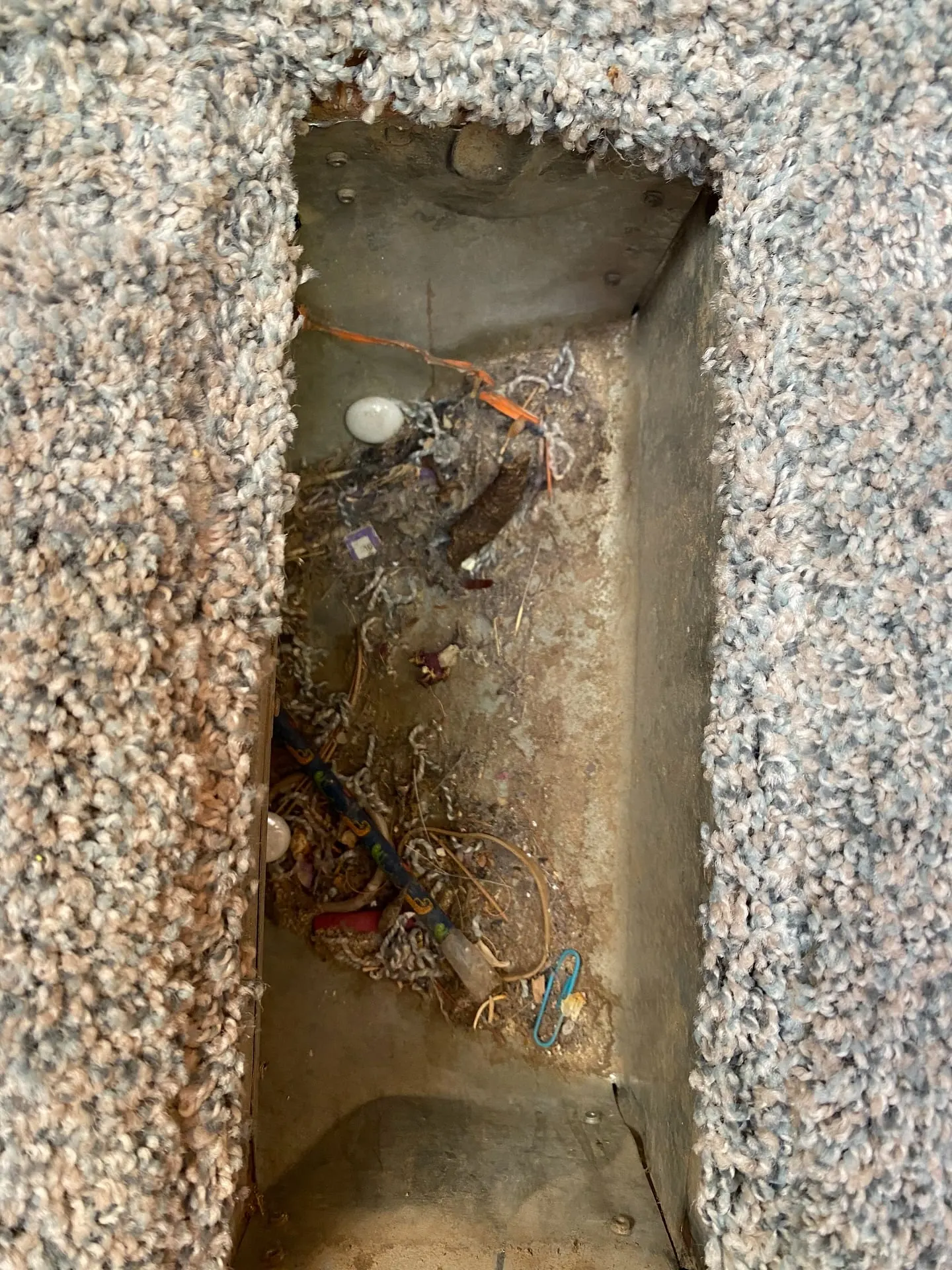 An open floor register packed with years of dust, hair and debris before cleaning