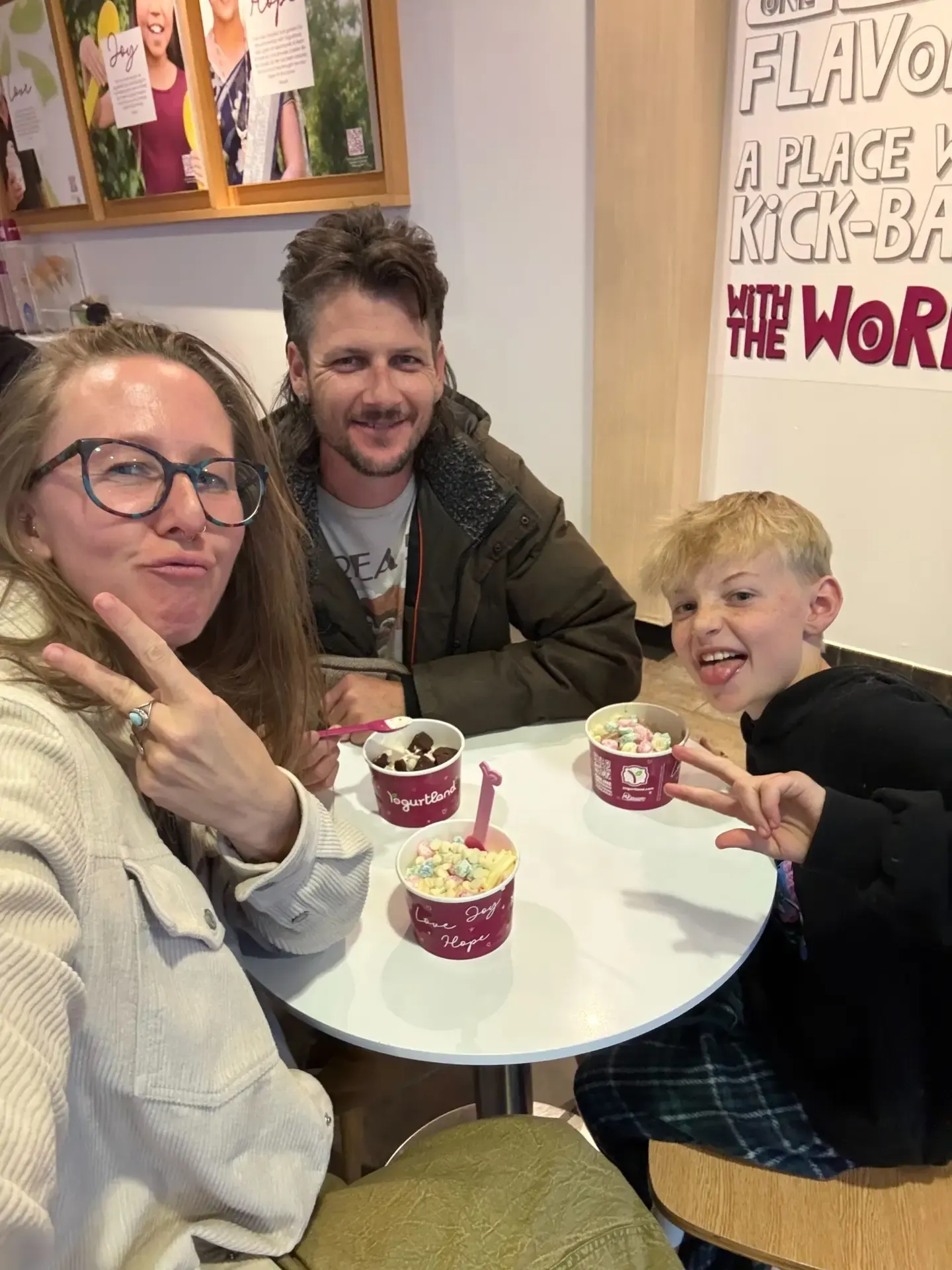Jake, his wife and son sharing ice cream at a cafe table
