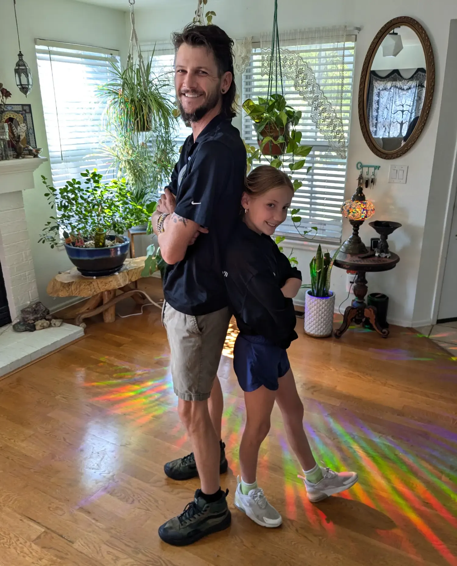 Jake and his son standing back to back in a sunny living room